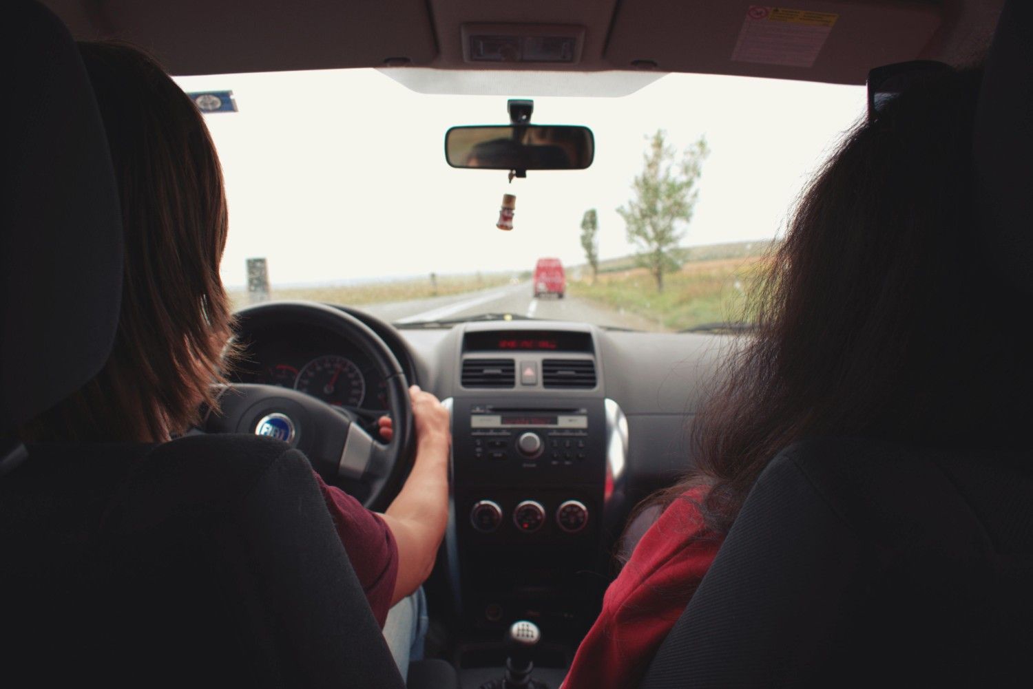 A modern steering wheel and dashboard reflecting a safe and focused driving experience on a clear highway